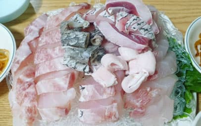 얼음 위에 다양하게 썰어 담아낸 민어회 한 접시와 곁들이 찬
