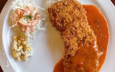 토마토 소스를 끼얹은 경양식 커틀릿과 샐러드, 마카로니가 담긴 접시