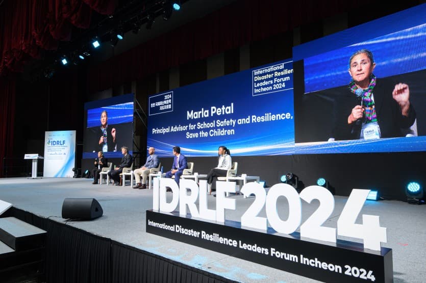 무대 위 'IDRLF 2024' 대형 로고 조형물 뒤로 패널들이 앉아 있고, 스크린에 발표자의 모습이 중계되는 세션 3 전경